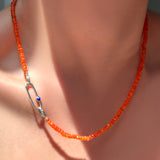 A faceted carnelian necklace with sterling silver evolution clasp holding a paperclip charm lock with lapis cabochon.