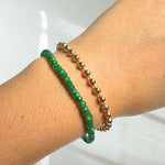 Faceted emerald gemstone beaded bracelet on a model's wrist with a 4mm recycled 14k gold bead chain bracelet.