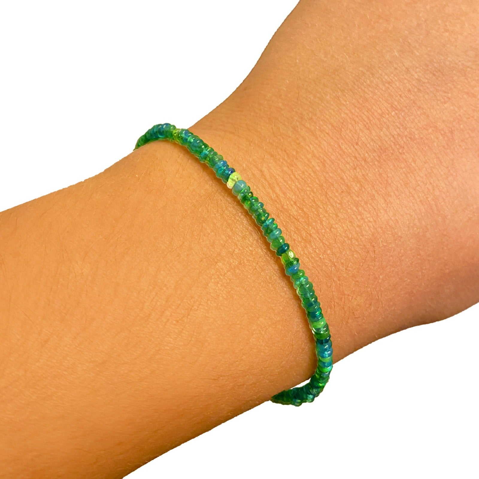 Shimmering beaded bracelet made of smooth opals in shades of green on a gold linking lobster clasp.