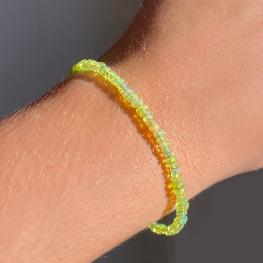 Shimmering beaded bracelet made of smooth opals in shades of light yellow on a gold linking lobster clasp.
