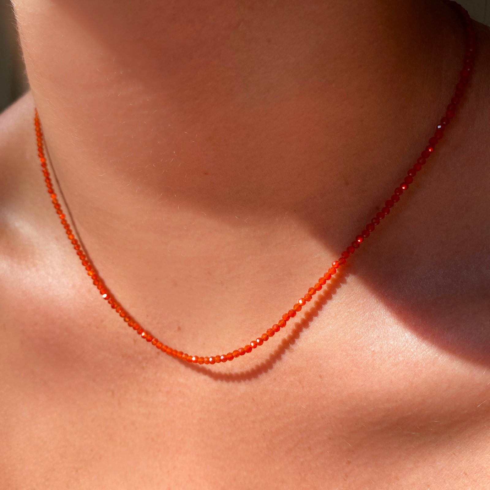 Shimmering beaded necklace made of 2mm faceted opals in shades of orange on a gold linking lobster clasp. 