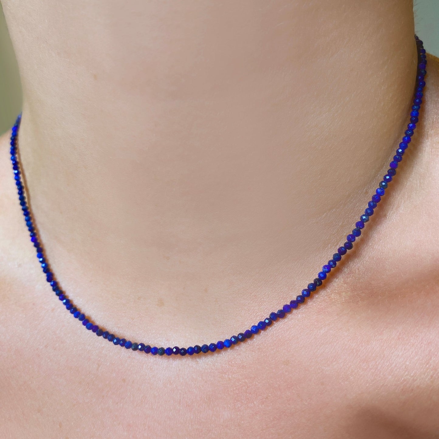 Shimmering beaded necklace made of 2mm faceted opals in shades of blue on a gold linking lobster clasp.