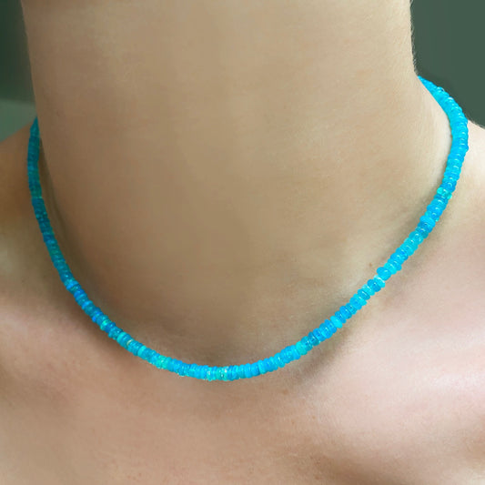 Shimmering beaded necklace made of smooth opal rondels in shades of bright light blue on a slim gold lobster clasp.