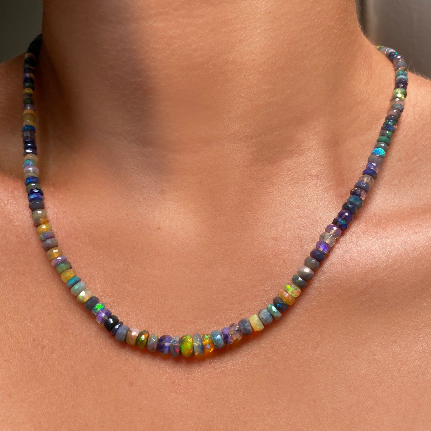 Shimmering beaded necklace made of faceted opals in shades of green, yellow, and blue on a gold linking ovals clasp.