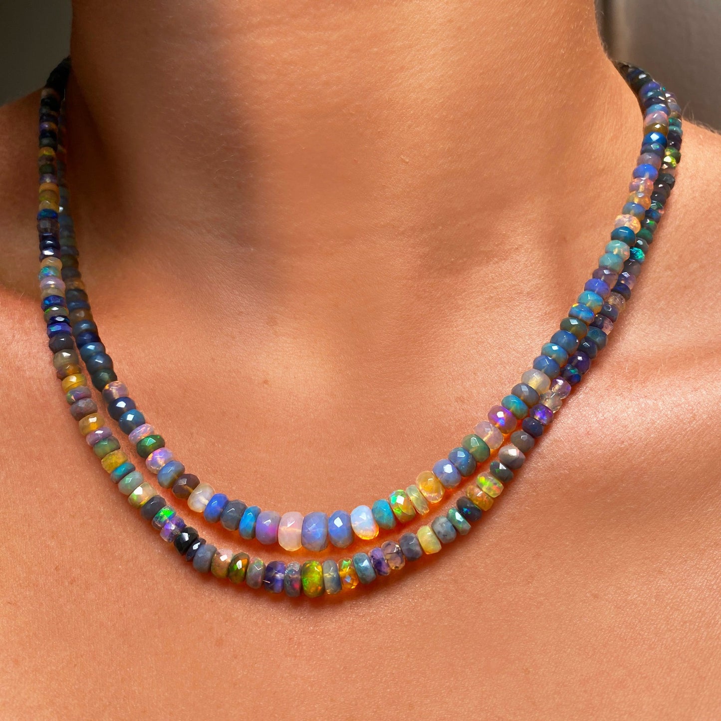 Shimmering beaded necklace made of faceted opals in shades of green, yellow, and blue on a gold linking ovals clasp.