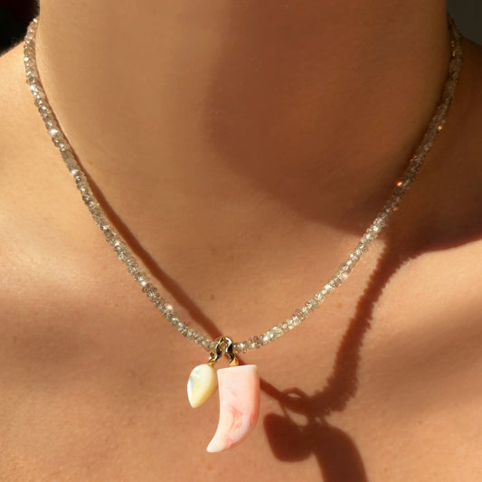 Pink opal horn charm. Styled on a neck with an acorn charm hanging from a beaded necklace.