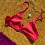 White Baroque Pearl Charm on Ripple bale on yellow gold bead chain paired with a bright red bikini on a yellow towel.