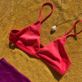 White Baroque Pearl Charm on Ripple bale on yellow gold bead chain paired with a bright red bikini on a yellow towel.