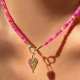 Shimmering Fuchsia Opal Necklace of smooth opals with various shades of pink, styled on a neck with a Medium Pavé Heart Charm 