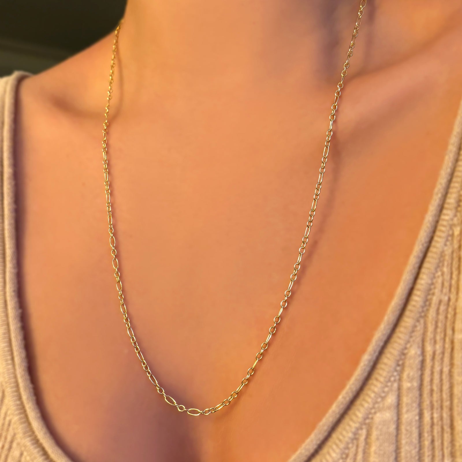 Irregular cable chain worn at 24" paired with a beige scoop neck knit.