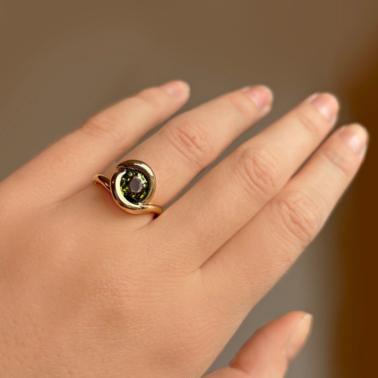 14k recycled gold Grass Green Tourmaline Molten Knot Ring styled on a hand