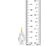 An AMANDA PEARL medium white baroque pearl against a ruler showing it's height to 29mm tall. It has a unique 14K recycled yellow gold ripple bale. 