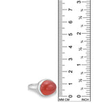A recycled sterling silver ring with an oval carnelian cabochon gemstone, shown next to a black ruler with millimeter and inch markings to indicate its size.