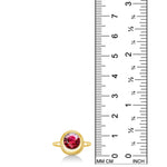 14K recycled yellow gold molten round solitaire with ruby, next to a ruler for scale, against a white background.