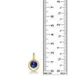 Molten Solitaire Charm in 14k yellow gold with a lab grown sapphire, set against a ruler showing a height of 20mm.