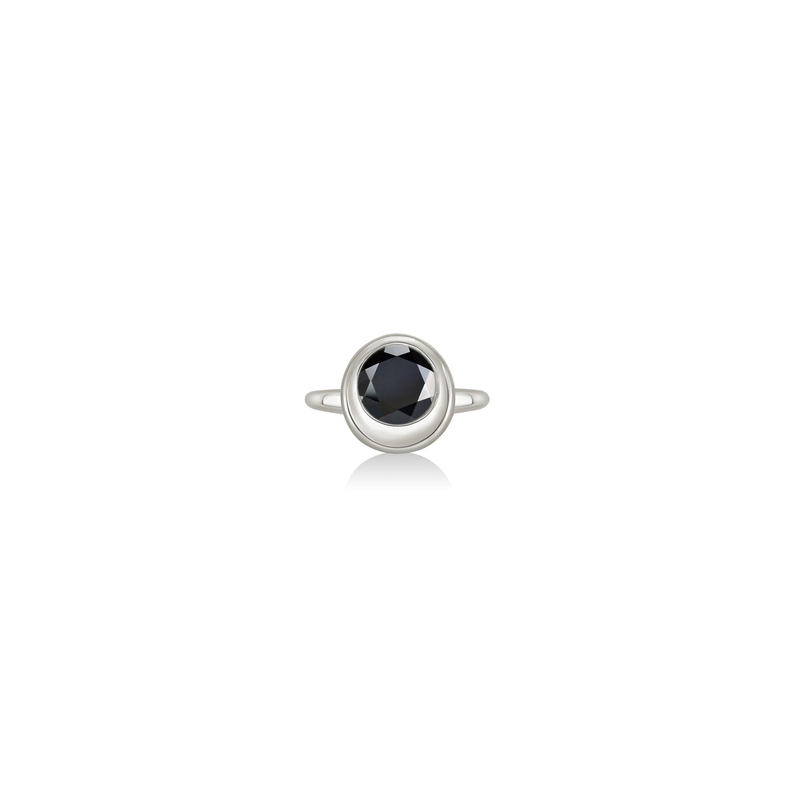 A white gold ring featuring a bezel-set round black gemstone, centered on a clean white background with a soft reflection below.