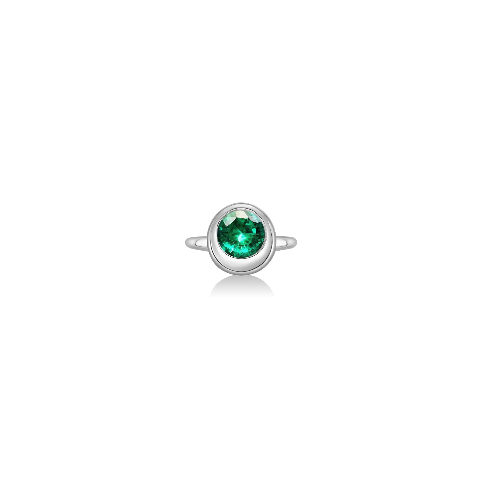 Molten solitaire ring in recycled 14k white gold with a round, cultivated emerald on a white background. 