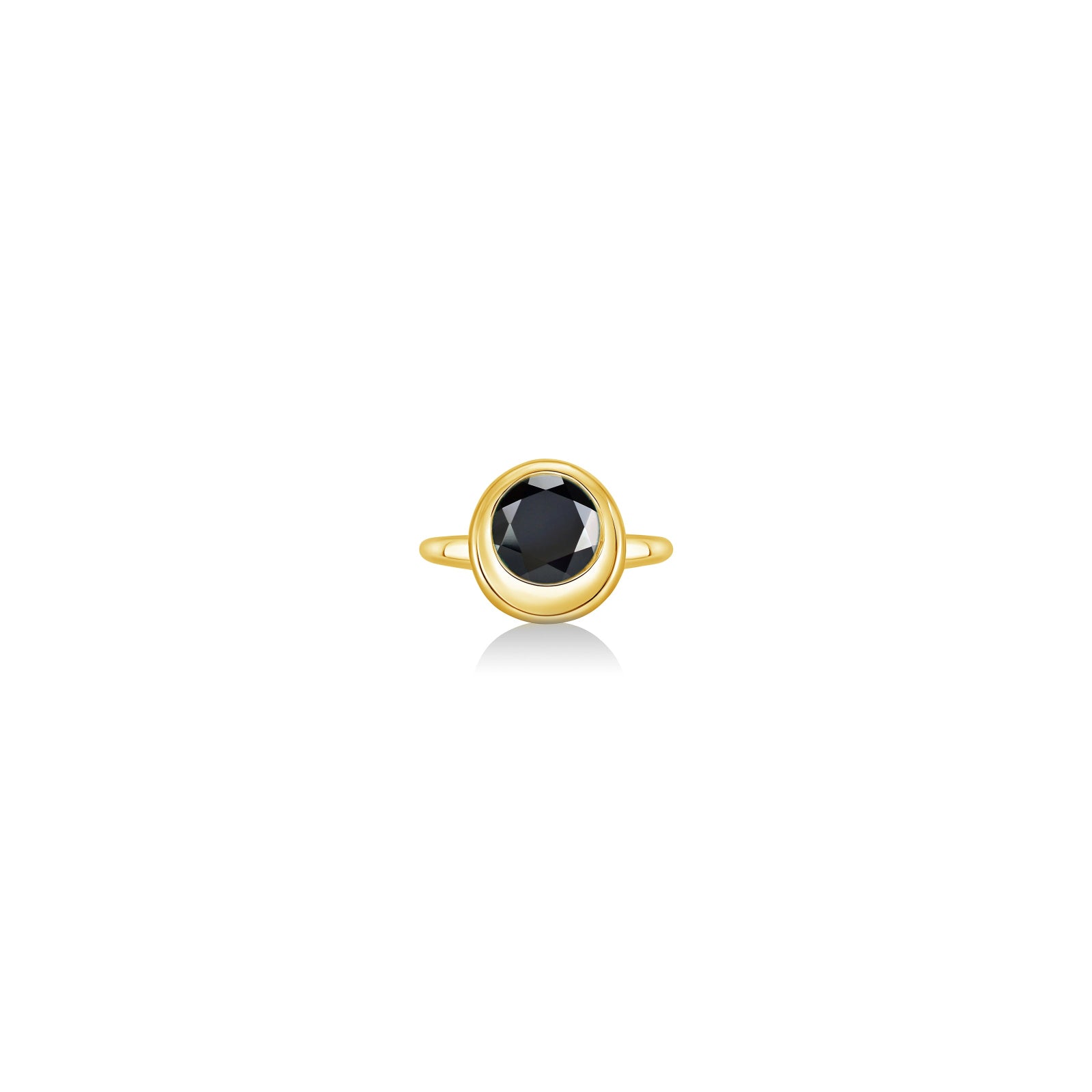A gold ring featuring a bezel-set round black gemstone, centered on a clean white background with a soft reflection below.