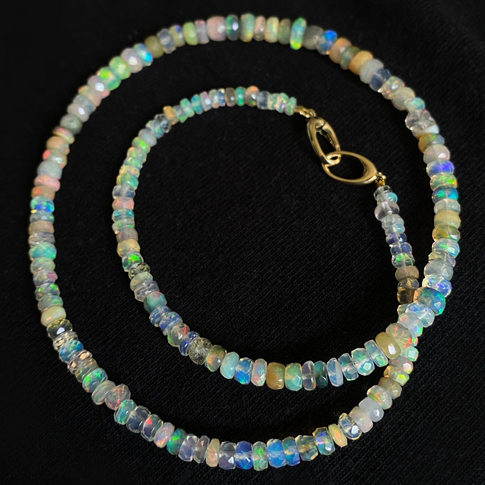 Shimmering beaded necklace made of faceted opals in shades of white, clear, and yellow on a gold linking ovals clasp.