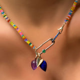 Paperclip charm lock with green onyx cabochon attached to a sapphire charm lock, attached to a garden party opal necklace with charms.
