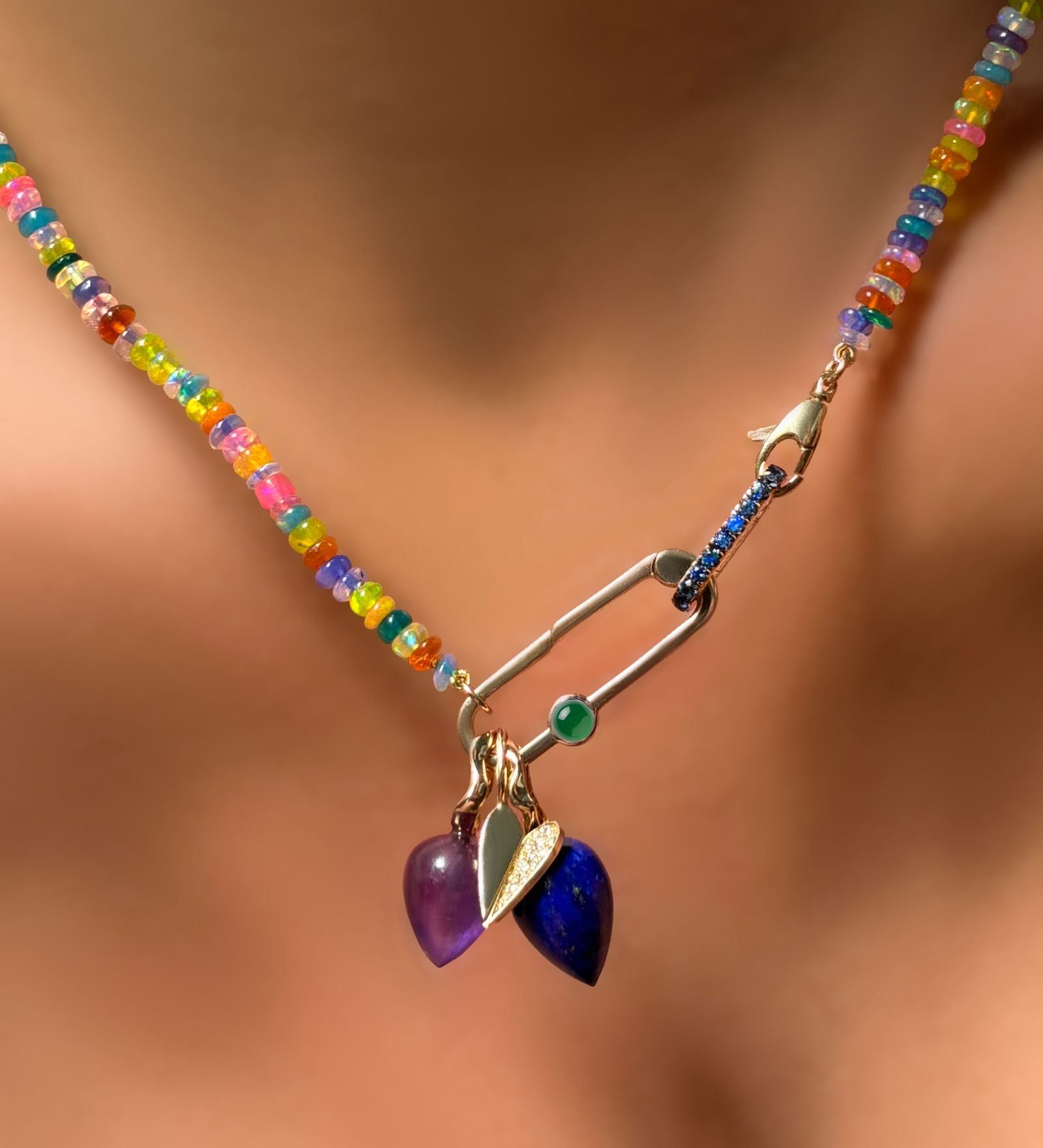 Paperclip charm lock with green onyx cabochon attached to a sapphire charm lock, attached to a garden party opal necklace with charms.