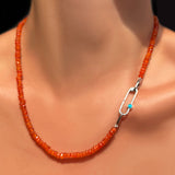An AMANDA PEARL faceted carnelian necklace on a recycled sterling silver evolution clasp holding a recycled sterling silver paperclip charm lock with turquoise cabochon.