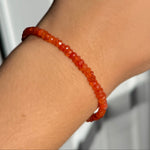 A model wearing an AMANDA PEARL faceted carnelian beaded bracelet.