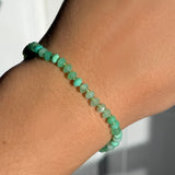 A faceted chrysoprase beaded bracelet from AMANDA PEARL on a model's wrist.