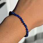 A model wearing an AMANDA PEARL faceted lapis beaded bracelet.