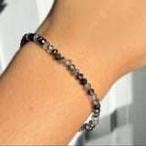 A  model wearing a faceted rutilated quartz beaded bracelet from AMANDA PEARL.