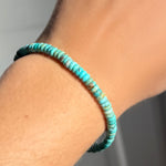 An AMANDA PEARL turquoise rondelle bracelet on a model's wrist.