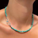 An AMANDA PEARL turquoise rondelle necklace on a recycled sterling silver evolution clasp holding a recycled sterling silver paperclip charm lock with turquoise cabochon.