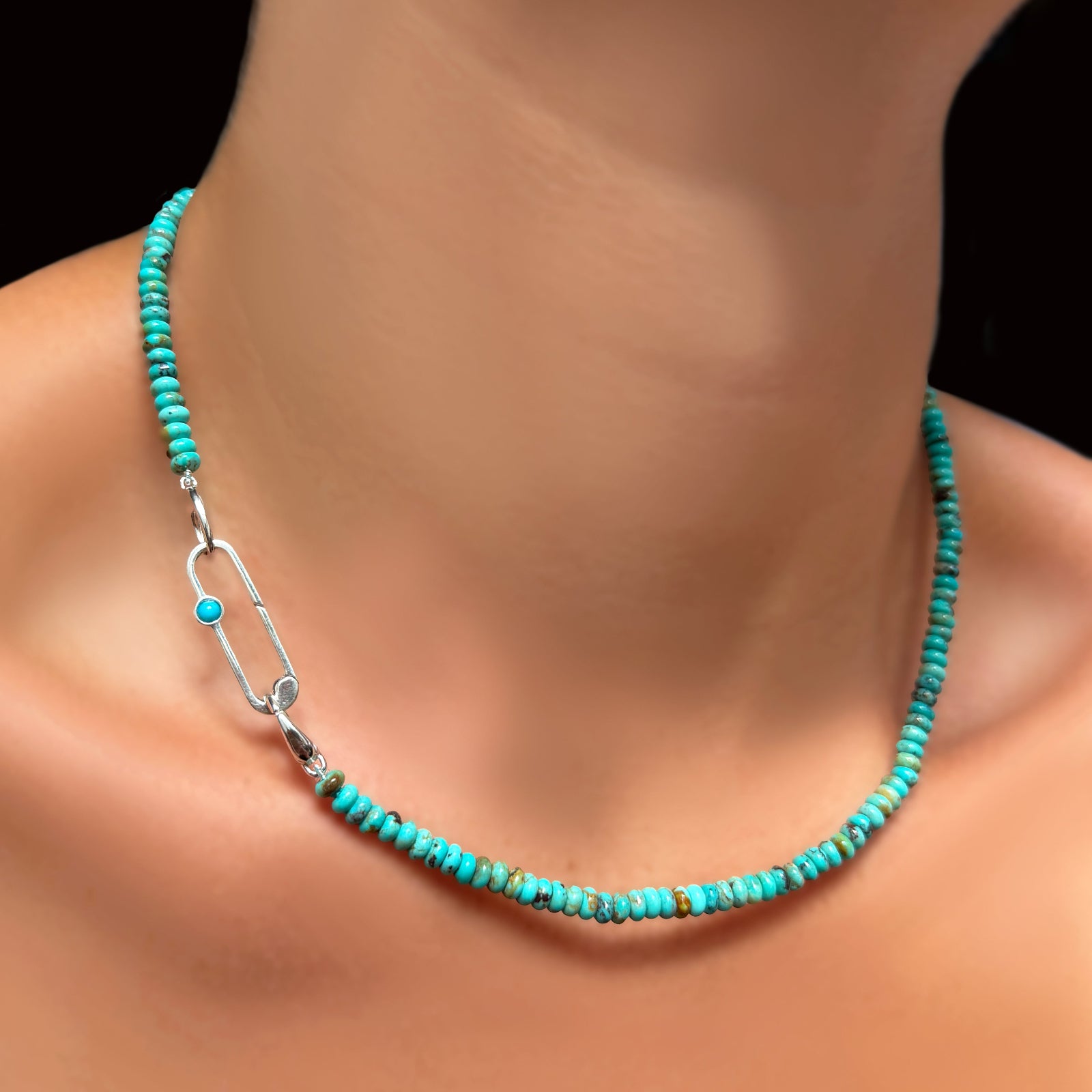 An AMANDA PEARL turquoise rondelle necklace on a recycled sterling silver evolution clasp holding a recycled sterling silver paperclip charm lock with turquoise cabochon.