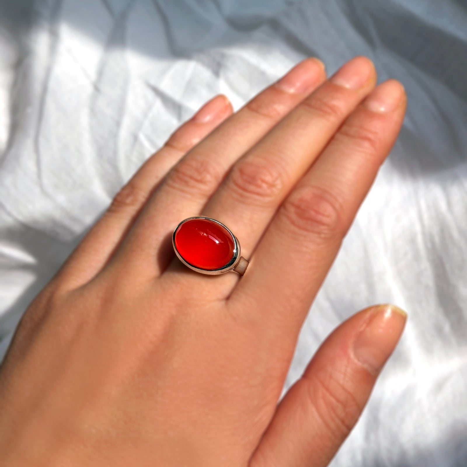 AMANDA PEARL recycled sterling silver and carnelian cabochon ring on a model's hand.