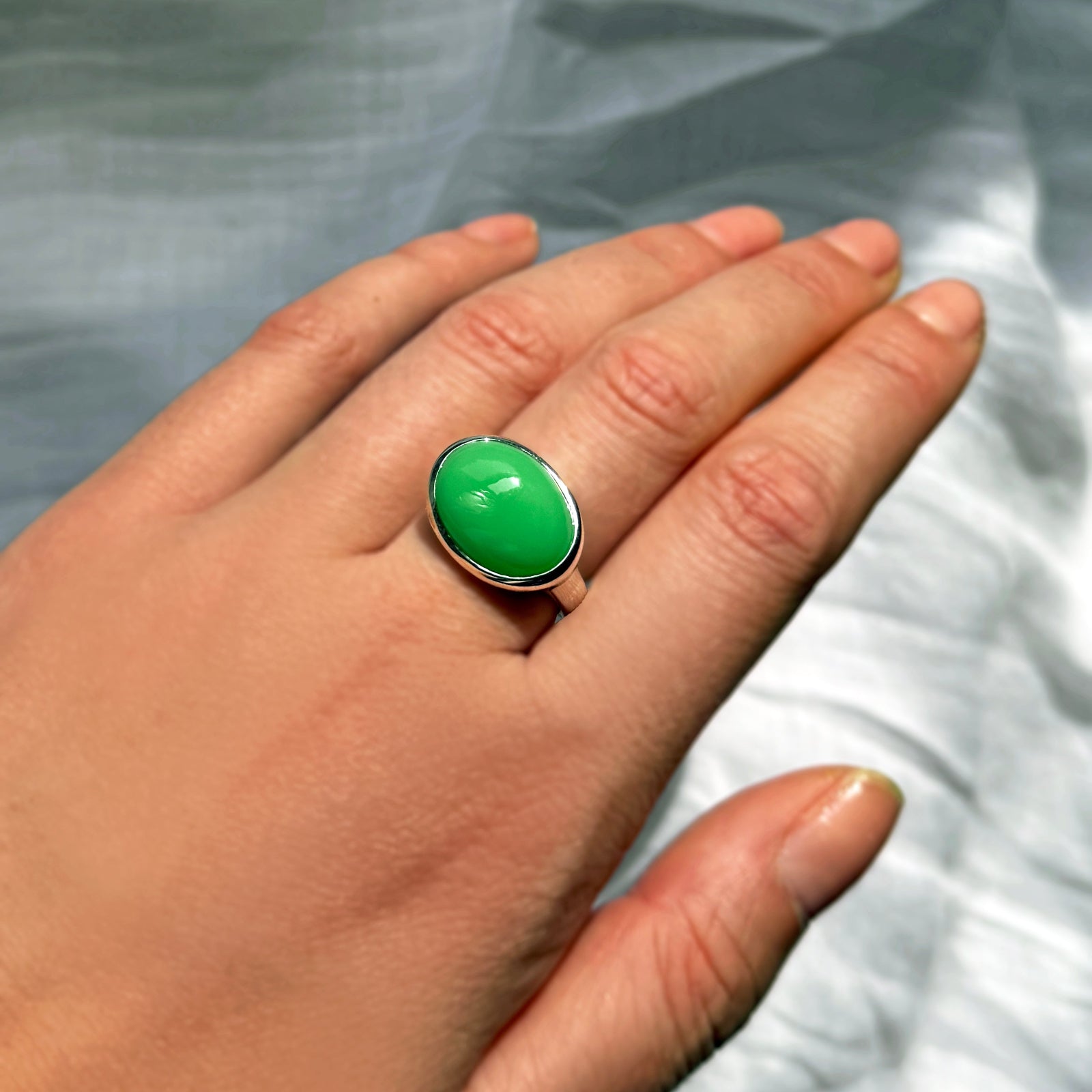An AMANDA PEARL recycled sterling silver molten pebble ring with chrysoprase cabochon.