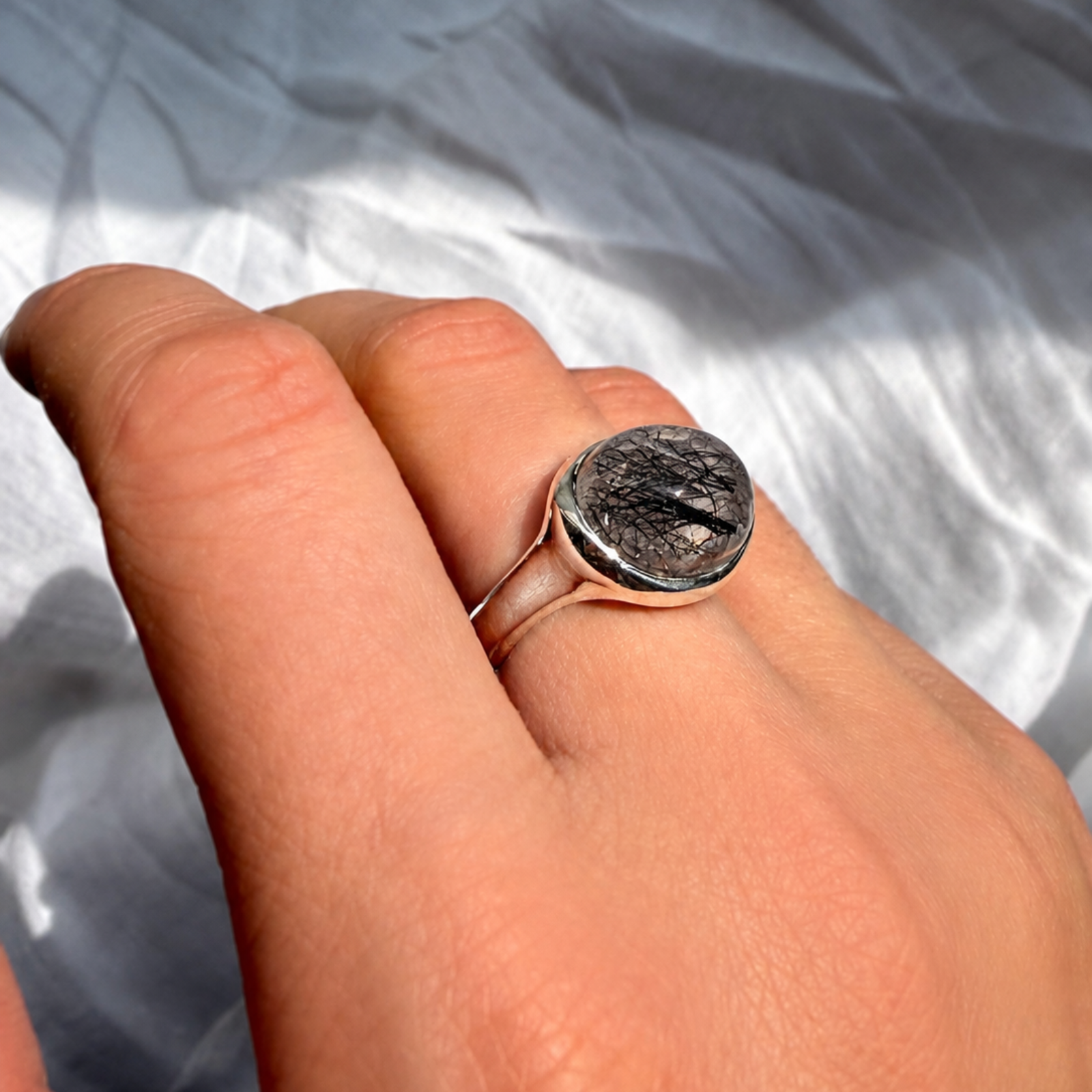 partial side view of rutilated quartz pebble ring in sterling silver