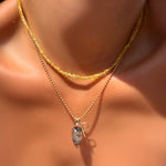Solar yellow faceted sapphire necklace layered over a bead chain with rutilated quartz drop and letter P charm on a model's neck.
