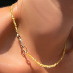 Solar yellow faceted sapphire necklace with a diamond pavé charm lock on a model's neck.