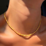 Solar yellow faceted sapphire necklace on a model's neck.