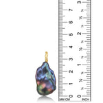 AMANDA PEARL Storm blue/purple/peacock baroque pearl with a white gold ripple bale on a white background next to a ruler.