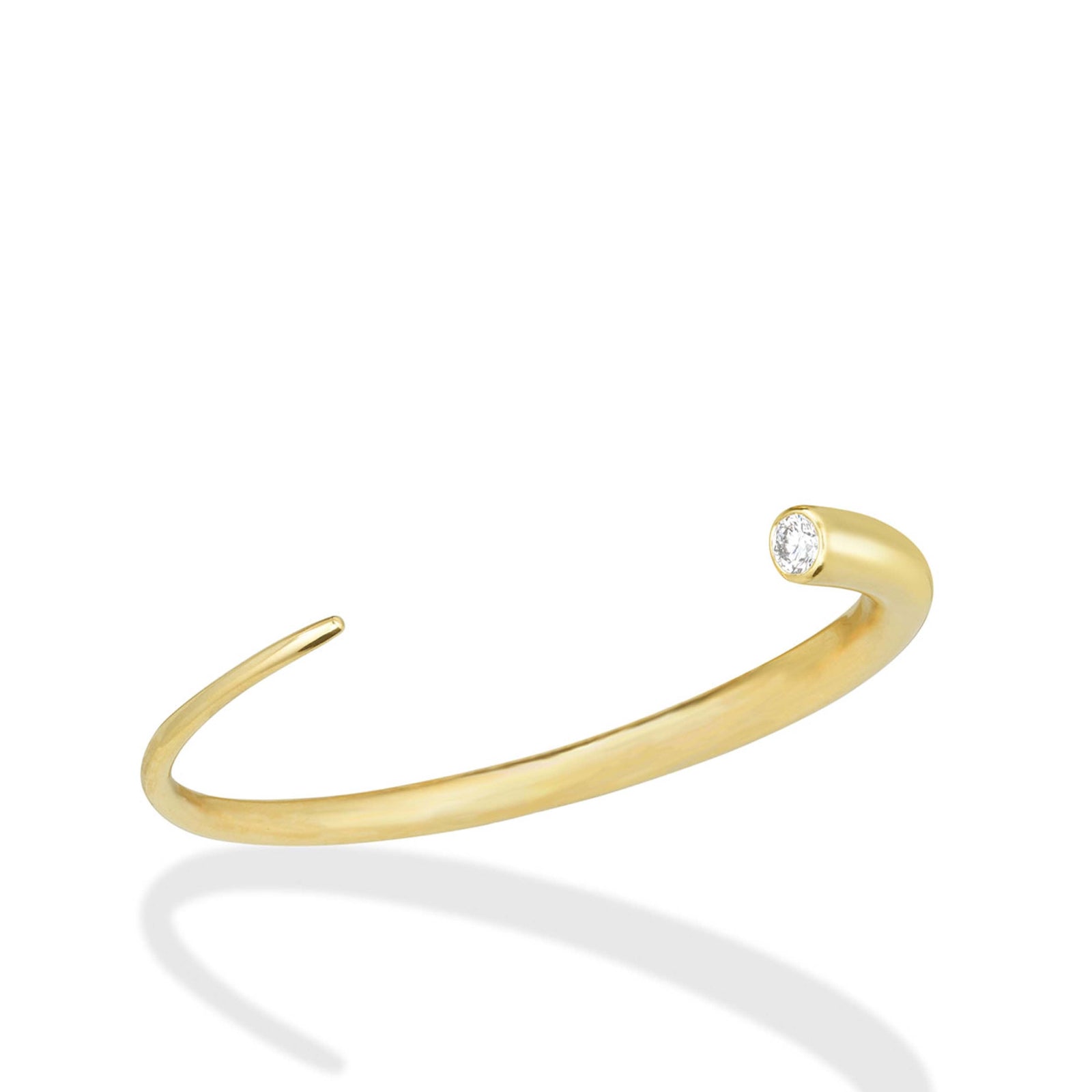 A 14K recycled yellow gold quill cuff with lab grown white diamond on a white background. 