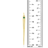 A quill spike charm from AMANDA PEARL in 14K recycled yellow gold with emerald sits against a ruler for scale.