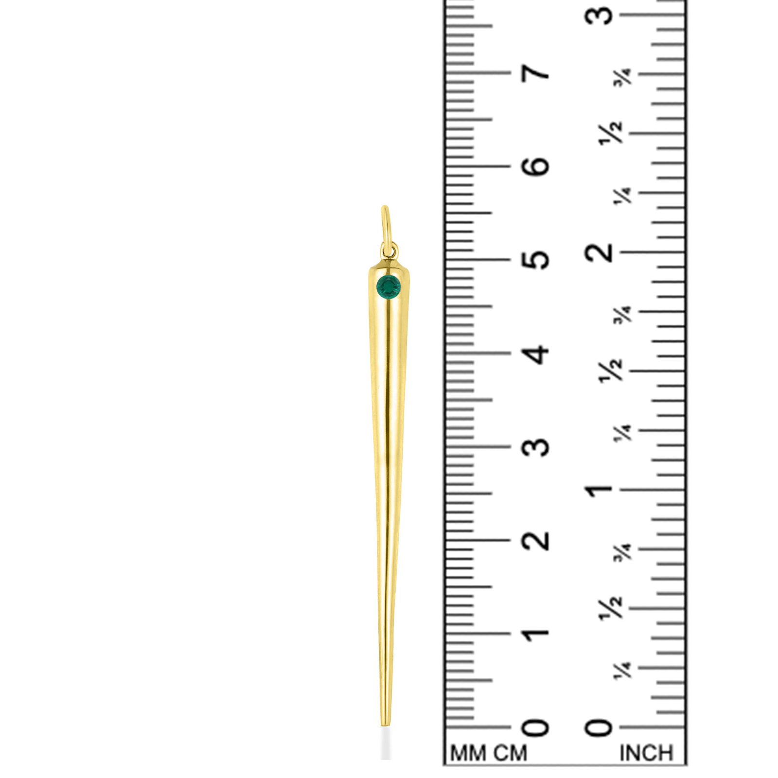 A quill spike charm from AMANDA PEARL in 14K recycled yellow gold with emerald sits against a ruler for scale.