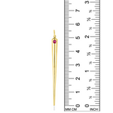 A quill spike charm from AMANDA PEARL in 14K recycled yellow gold with ruby sits against a ruler for scale.