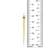 A quill spike charm from AMANDA PEARL in 14K recycled yellow gold with sapphire sits against a ruler for scale.