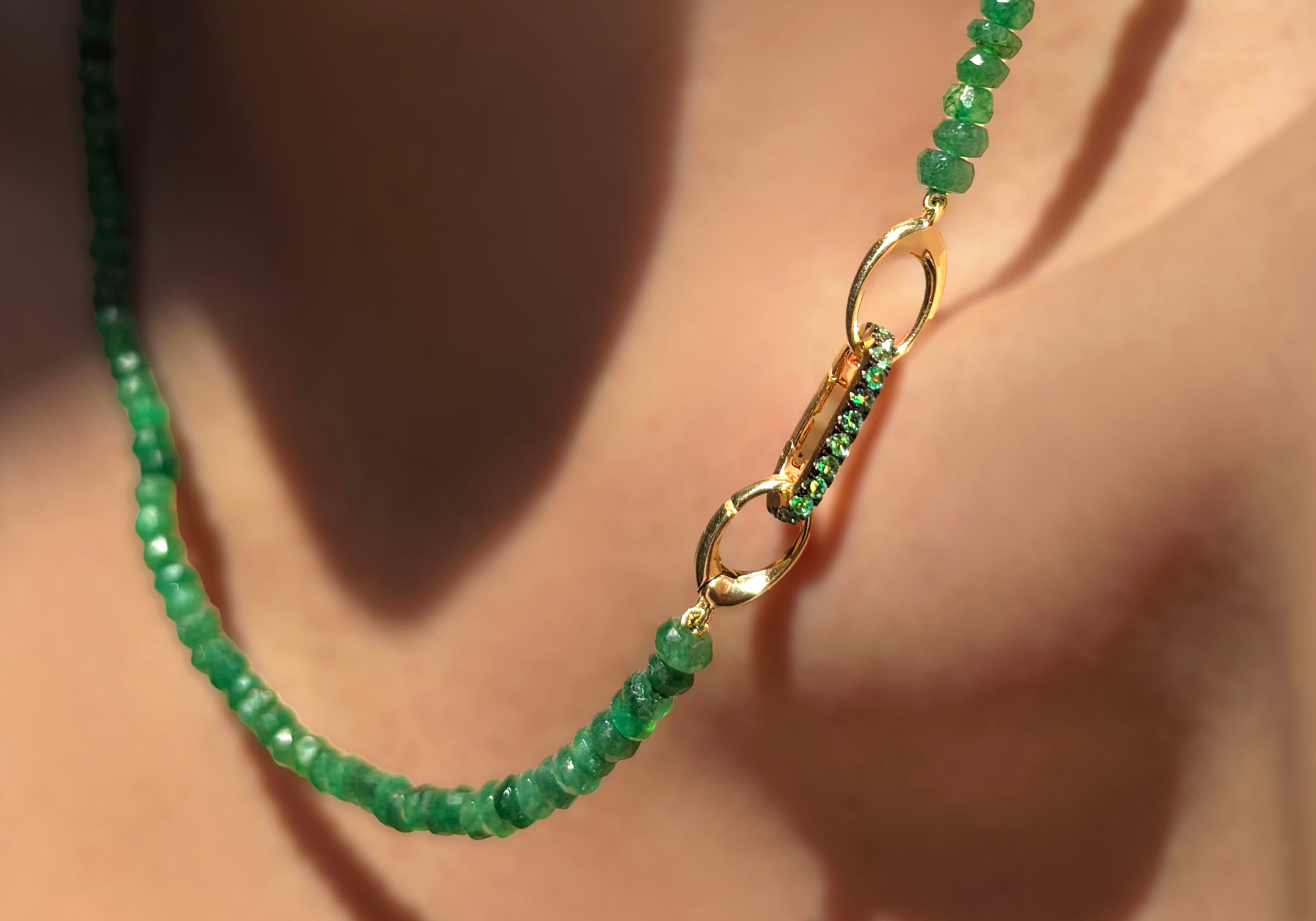 AMANDA PEARL emerald beaded necklace with 14K gold evolution clasp with an emerald charm lock, showing a styling option.