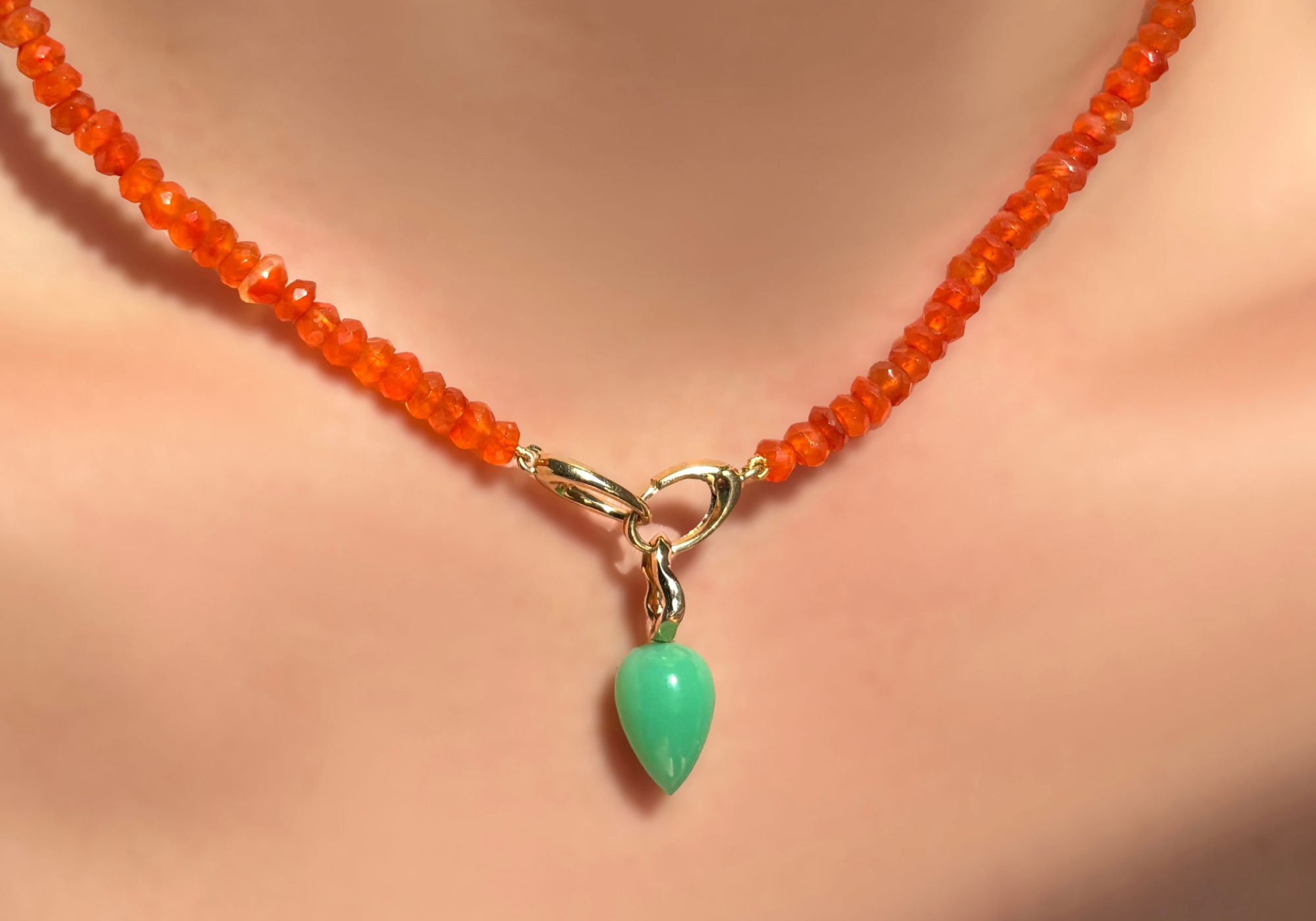 AMANDA PEARL carnelian faceted beaded necklace with an evolution clasp from which hangs a chrysoprase drop charm with 14K recycled yellow gold ripple bale. This picture shows how you could style your evolution clasp.