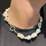 Baroque Pearl Collar with a round pavé face charm lock in the clasp on a model wearing a black tee.