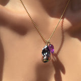 2mm bead chain with storm blue baroque pearl and faceted amethyst drop charm on ripple bale on a model's neck.