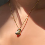 AMANDA PEARL recycled 14k gold heart charm on 2mm bead chain on a model's neck.